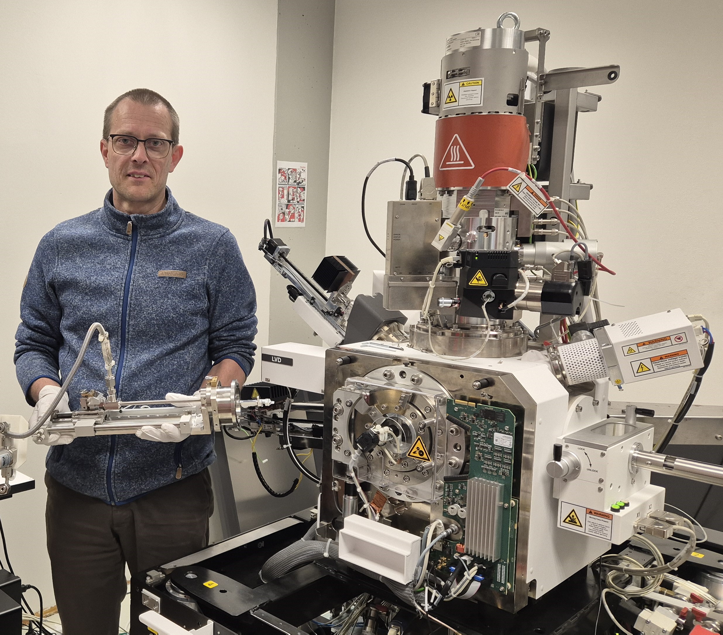 Libor Novák, Ph.D., R&D manager at Thermo Fisher, is pictured holding the MicroReactor next to a scanning electron microscope.