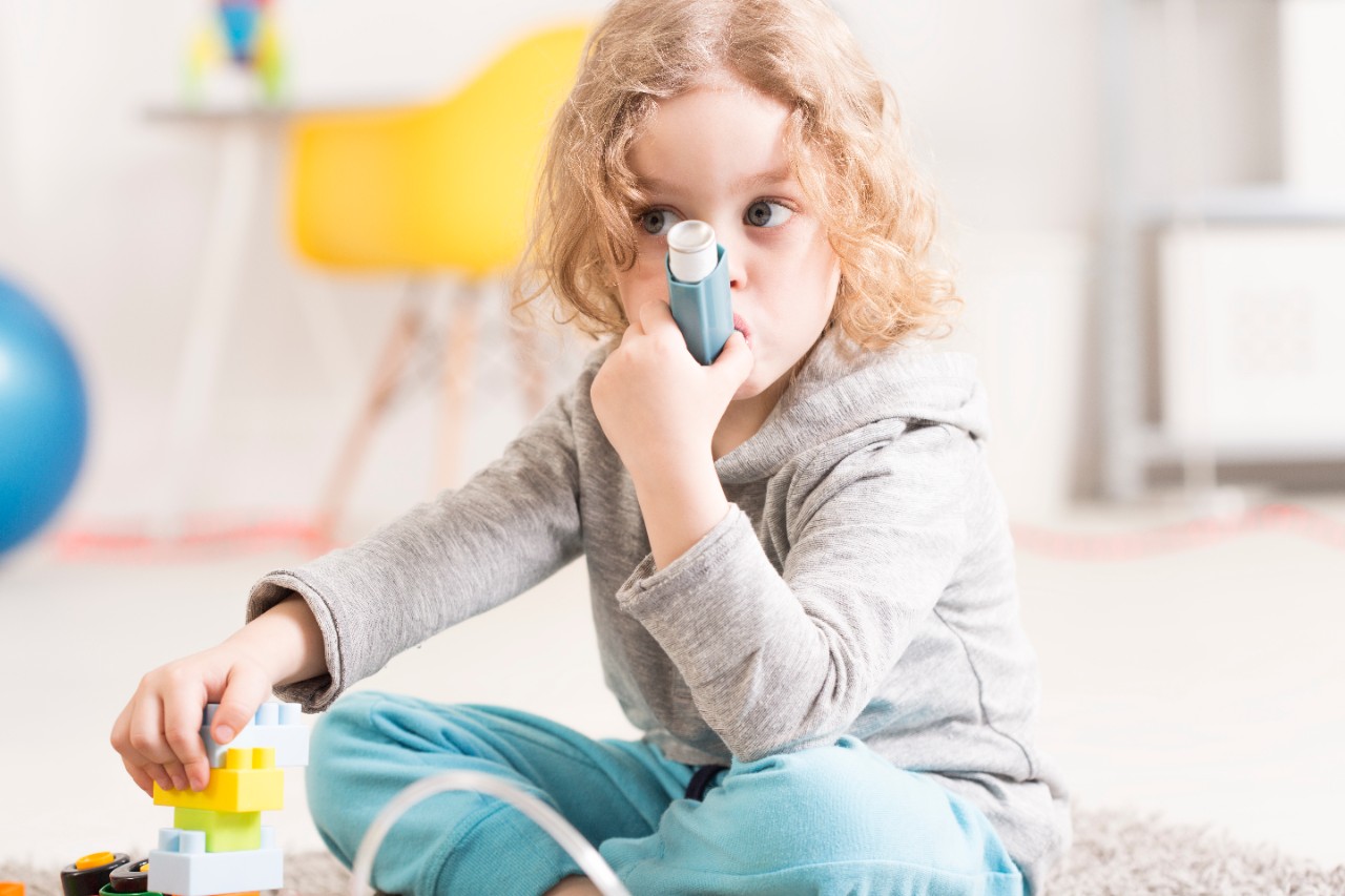 little girl using inhaler