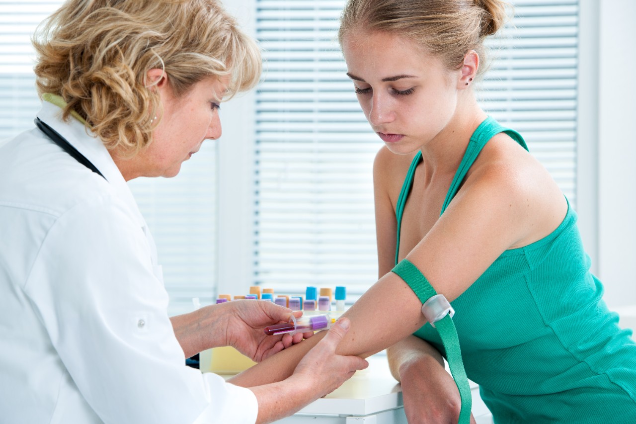 doctor taking blood from woman