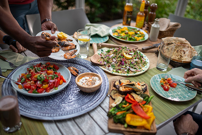 Close up of table with several plates of Mediterranean food and dips