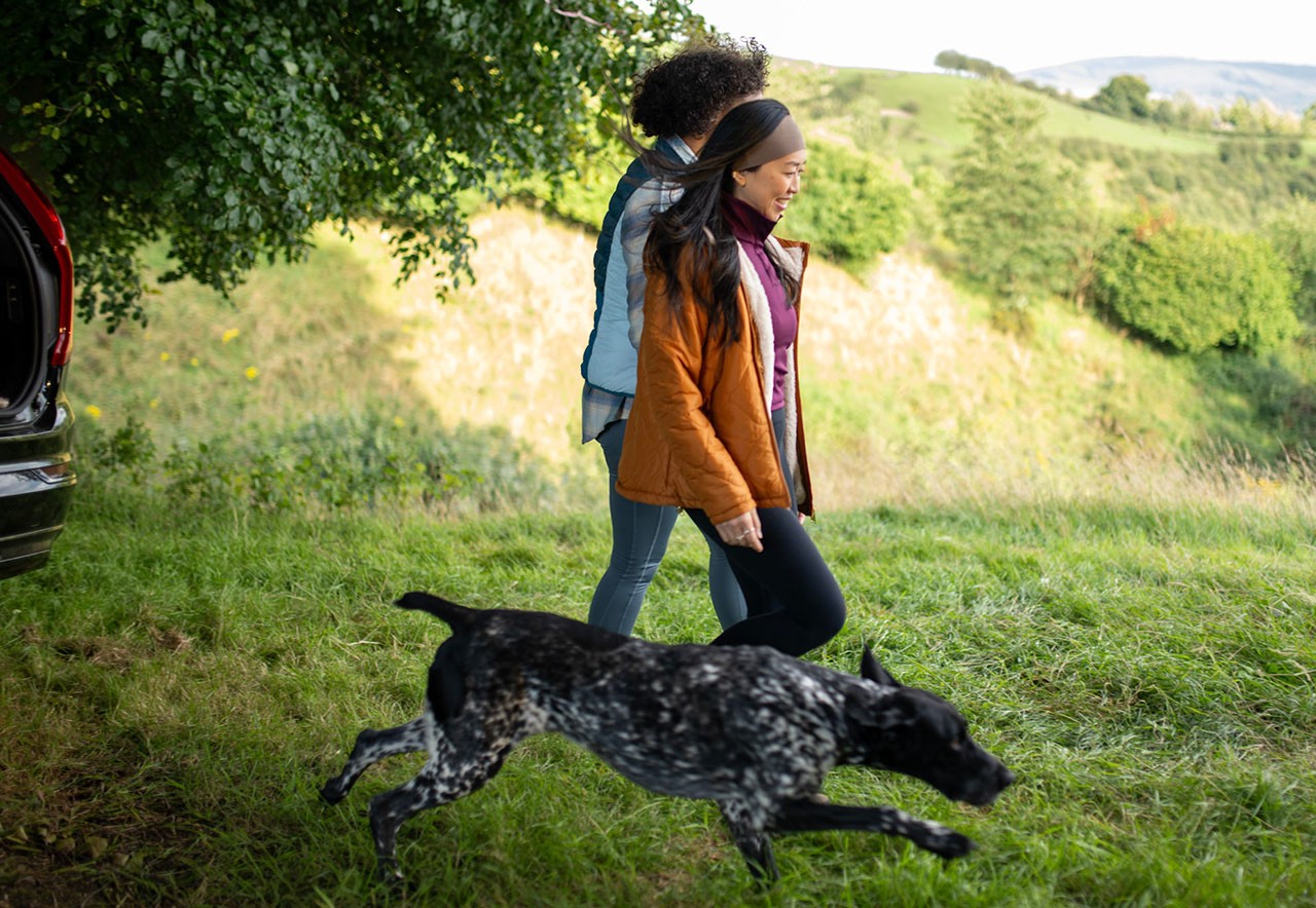 Una pareja joven paseando a su perro afuera