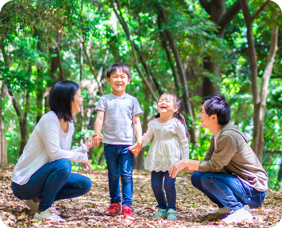 Family outside laughing on a floor of leaves.