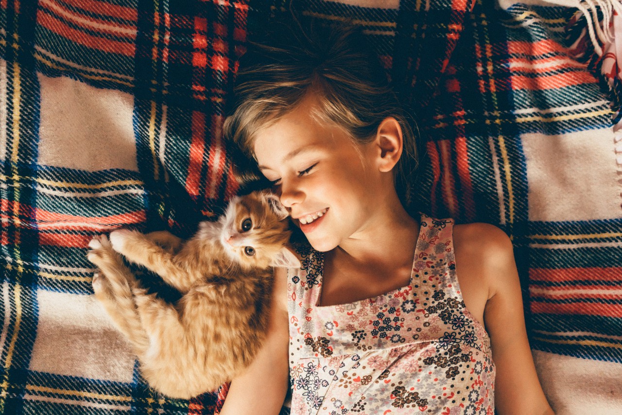 Girl laying down with a cat on her shoulder | Eczema causes